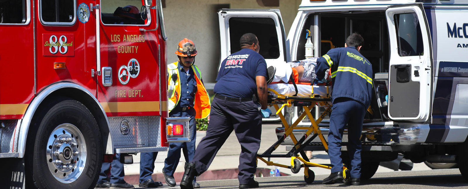 paramedics rolling patient into ambulance